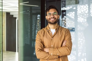 Smiling employee with folded arms showing positive tech company culture.
